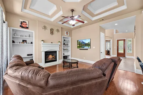 a living room with furniture fireplace and a large window