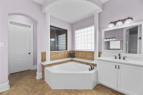 a spacious bathroom with a double vanity sink a mirror and a