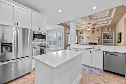 a large white kitchen with cabinets a sink and stainless steel appliances