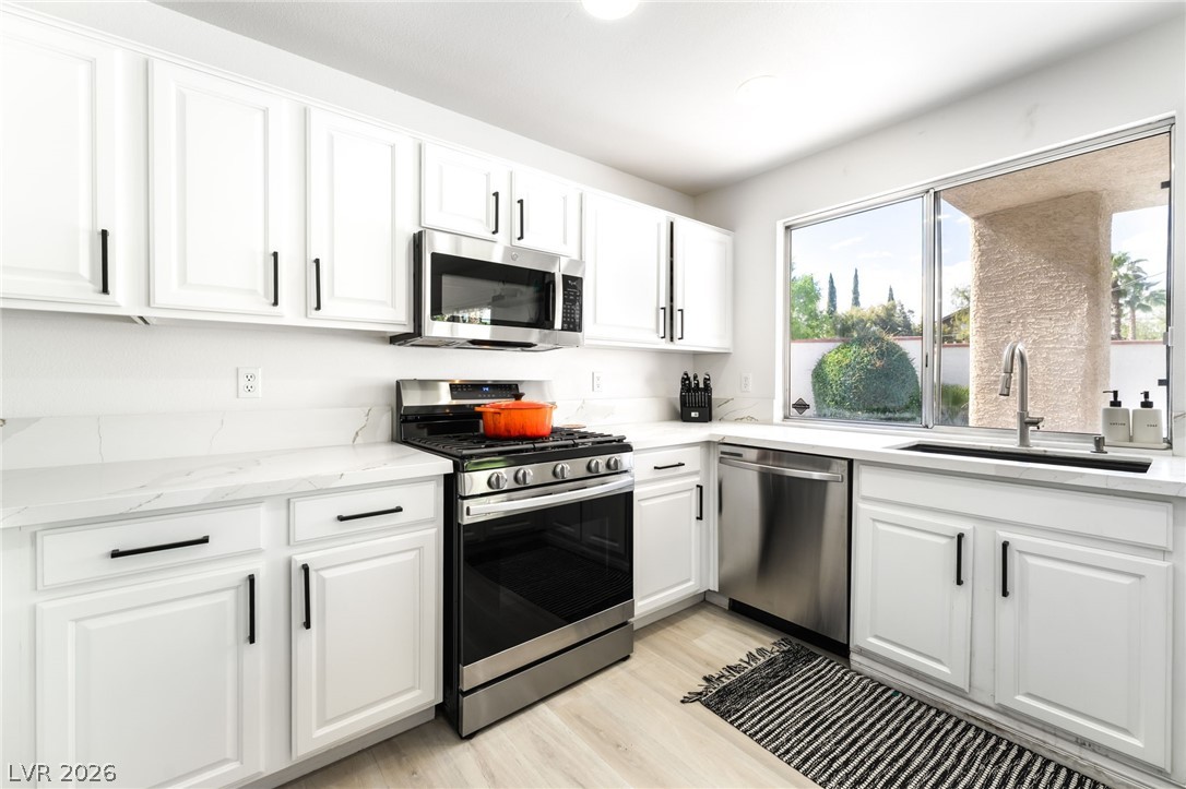 1941 Ivy Point Lane Las Vegas, NV 89134 - Photo 8 of 21 A well-equipped kitchen features bright cabinetry, stainless steel appliances, and a window overlooking lush landscaping.