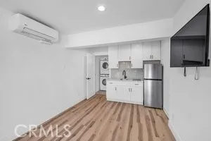 a kitchen with white cabinets and refrigerator