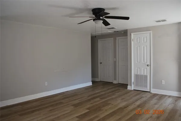 a view of an empty room with wooden floor