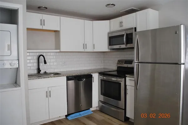 a kitchen with stainless steel appliances granite countertop a refrigerator stove and sink