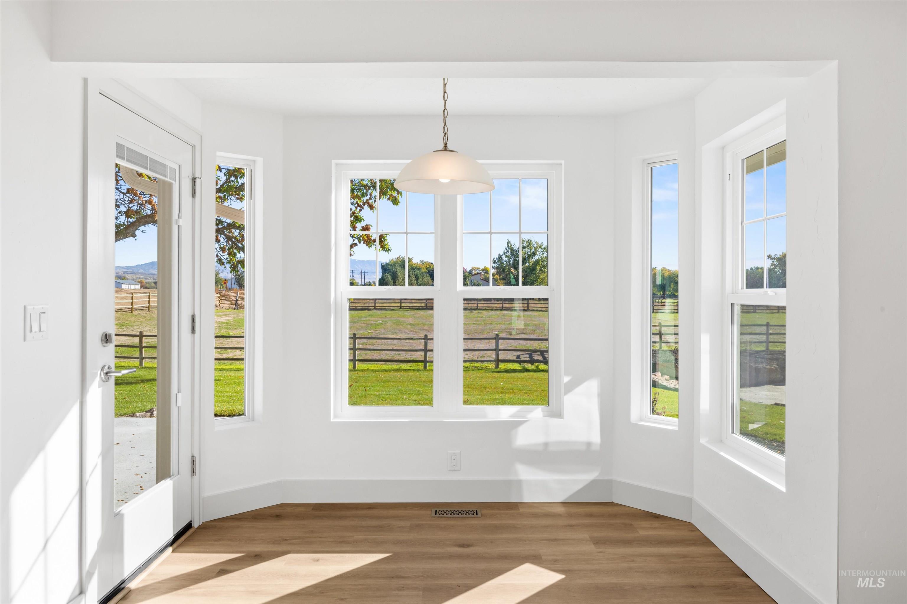 2141 West Beacon Light Road Eagle, ID 83616 - Photo 13 of 46 Unfurnished dining area with wood finished floors and baseboards