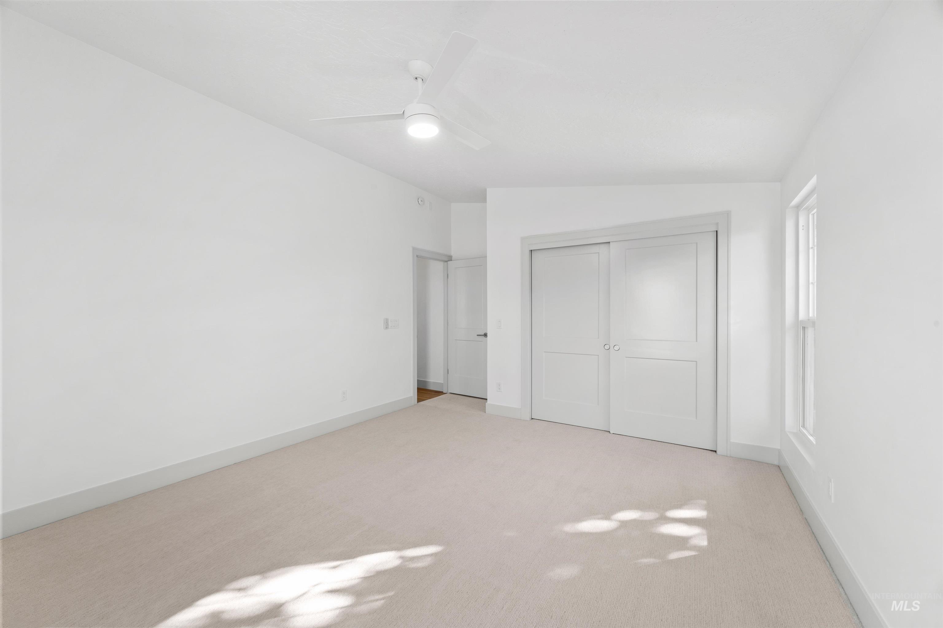 2141 West Beacon Light Road Eagle, ID 83616 - Photo 23 of 46 Unfurnished bedroom with carpet floors, a closet, a ceiling fan, and lofted ceiling