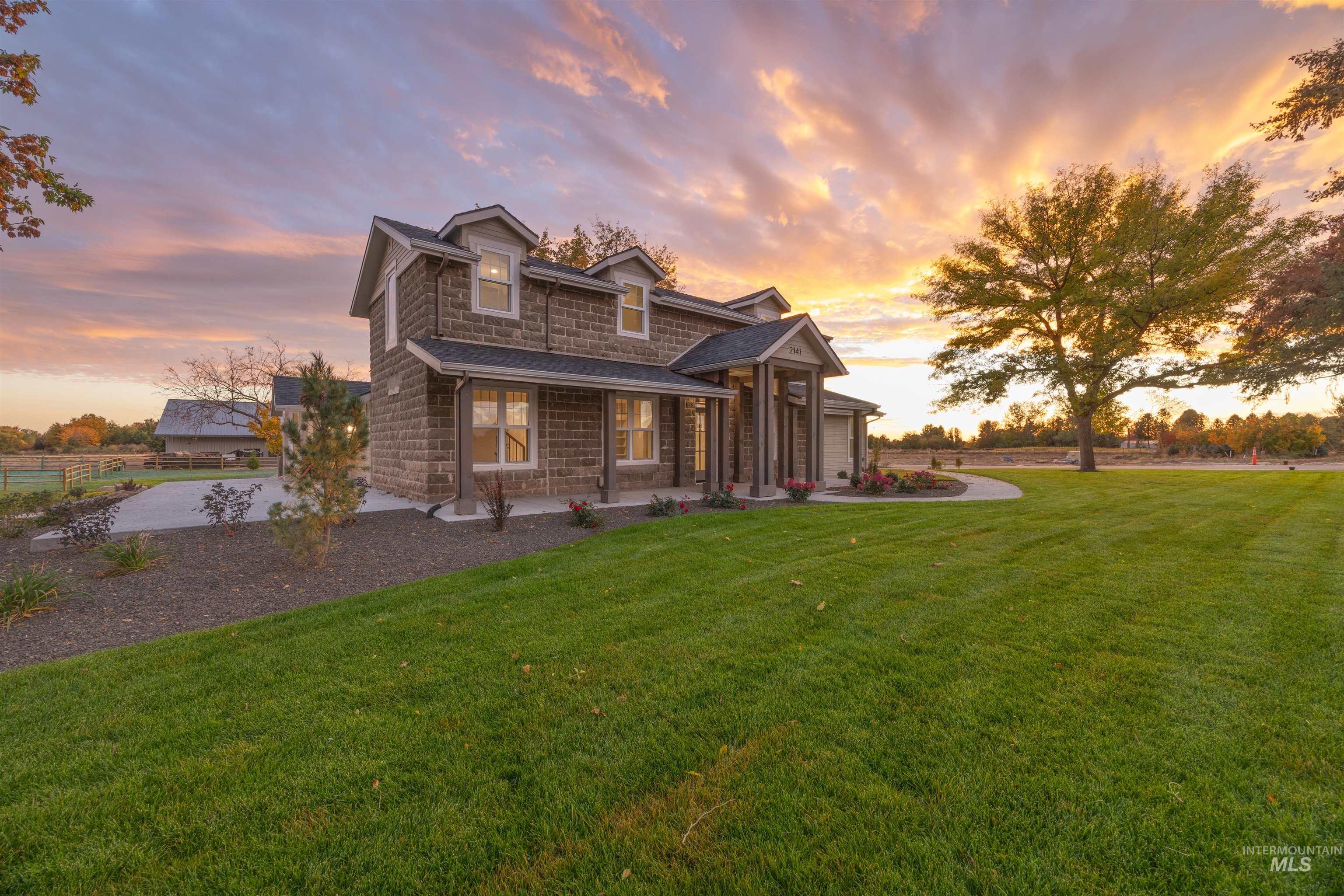 2141 West Beacon Light Road Eagle, ID 83616 - Photo 3 of 46 View of front facade featuring a front lawn, stone siding, and a porch