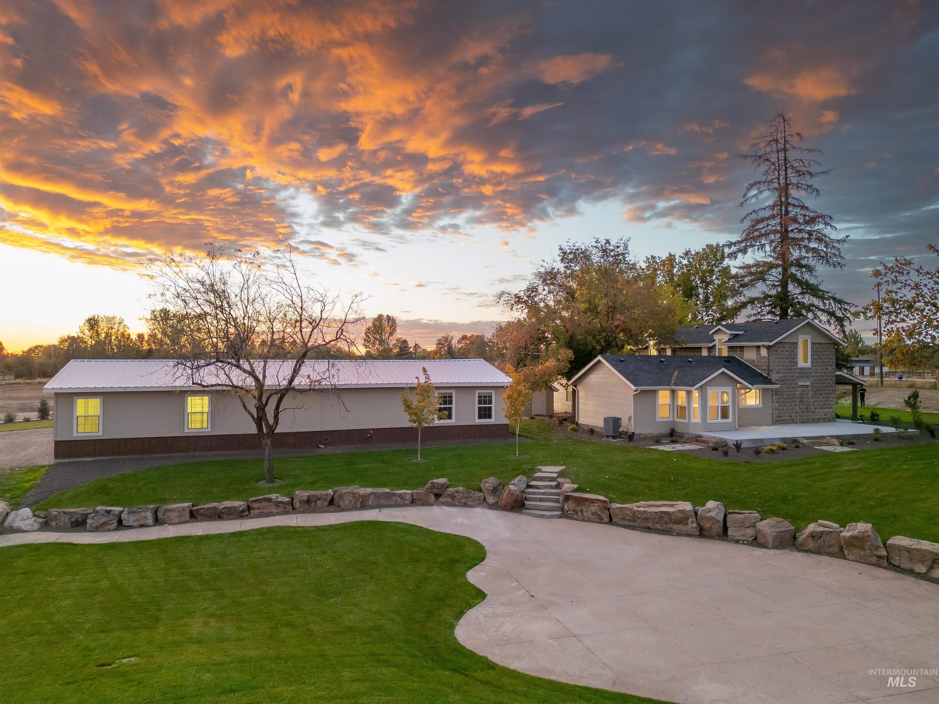 2141 West Beacon Light Road Eagle, ID 83616 - Photo 38 of 46 Back of property at dusk featuring a yard, a metal roof, and a patio