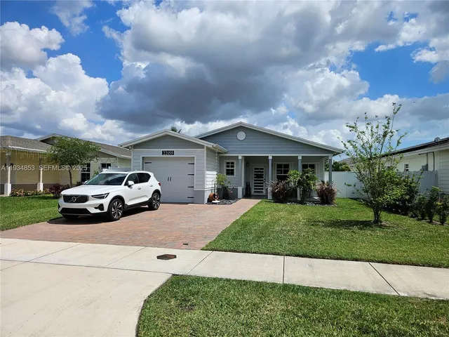 a white house covered with tall trees