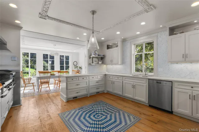 a kitchen with stainless steel appliances granite countertop hardwood floor sink stove dining table and chairs