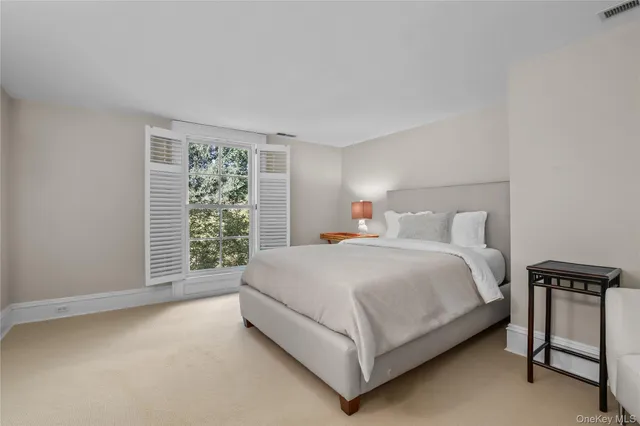 a bed sitting in a bedroom next to a window