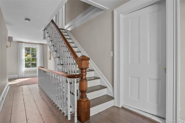 a view of staircase with wooden floor and white walls