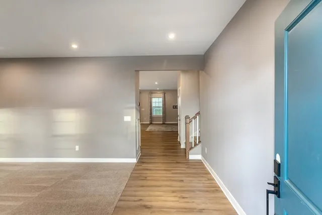 a view of a hallway with wooden floor and staircase