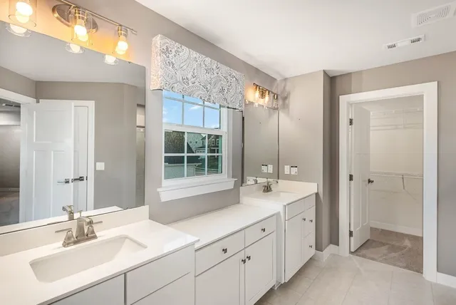 a spacious bathroom with a double vanity sink mirror and double
