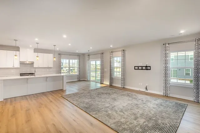 a large kitchen with kitchen island a sink wooden floor and a refrigerator
