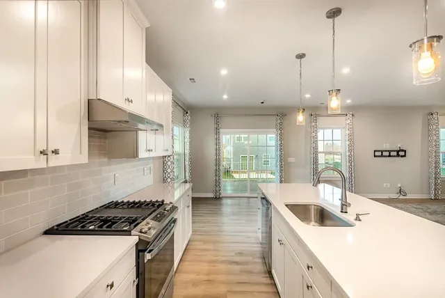 a kitchen with granite countertop a sink a counter top space and cabinets