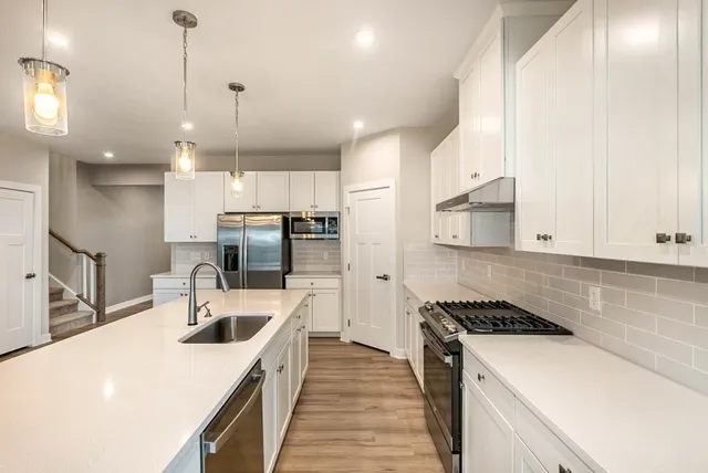 a kitchen with a sink a stove and chairs