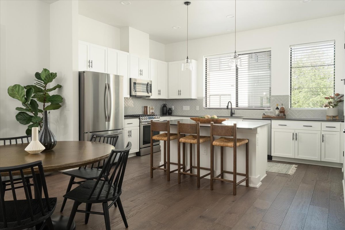 3700 Clawson Road, Unit 301 Austin, TX 78704 - Photo 5 of 35 Dining area and kitchen featuring white cabinetry, stainless steel appliances, hanging light fixtures, and a center island