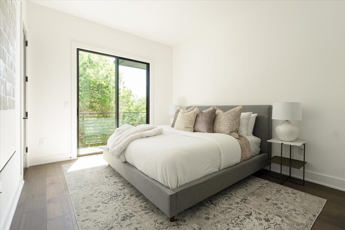 3700 Clawson Road, Unit 301 Austin, TX 78704 - Photo 7 of 35 Primary Bedroom showcasing a king bed and access to balcony overlooking the central park area