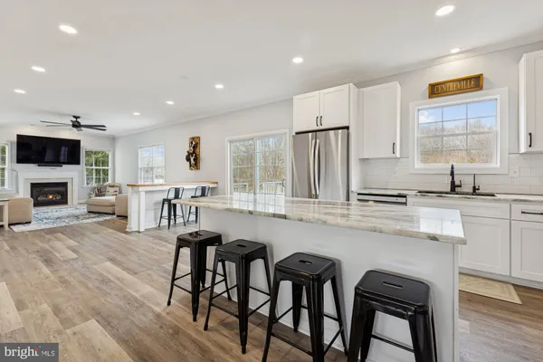 a kitchen with stainless steel appliances a table and chairs in it