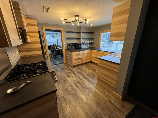 a kitchen with wooden floor and a stove top oven