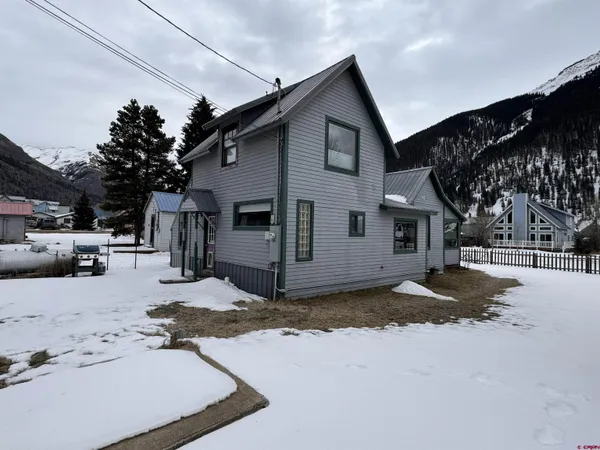 a view of a house with a yard covered in snow