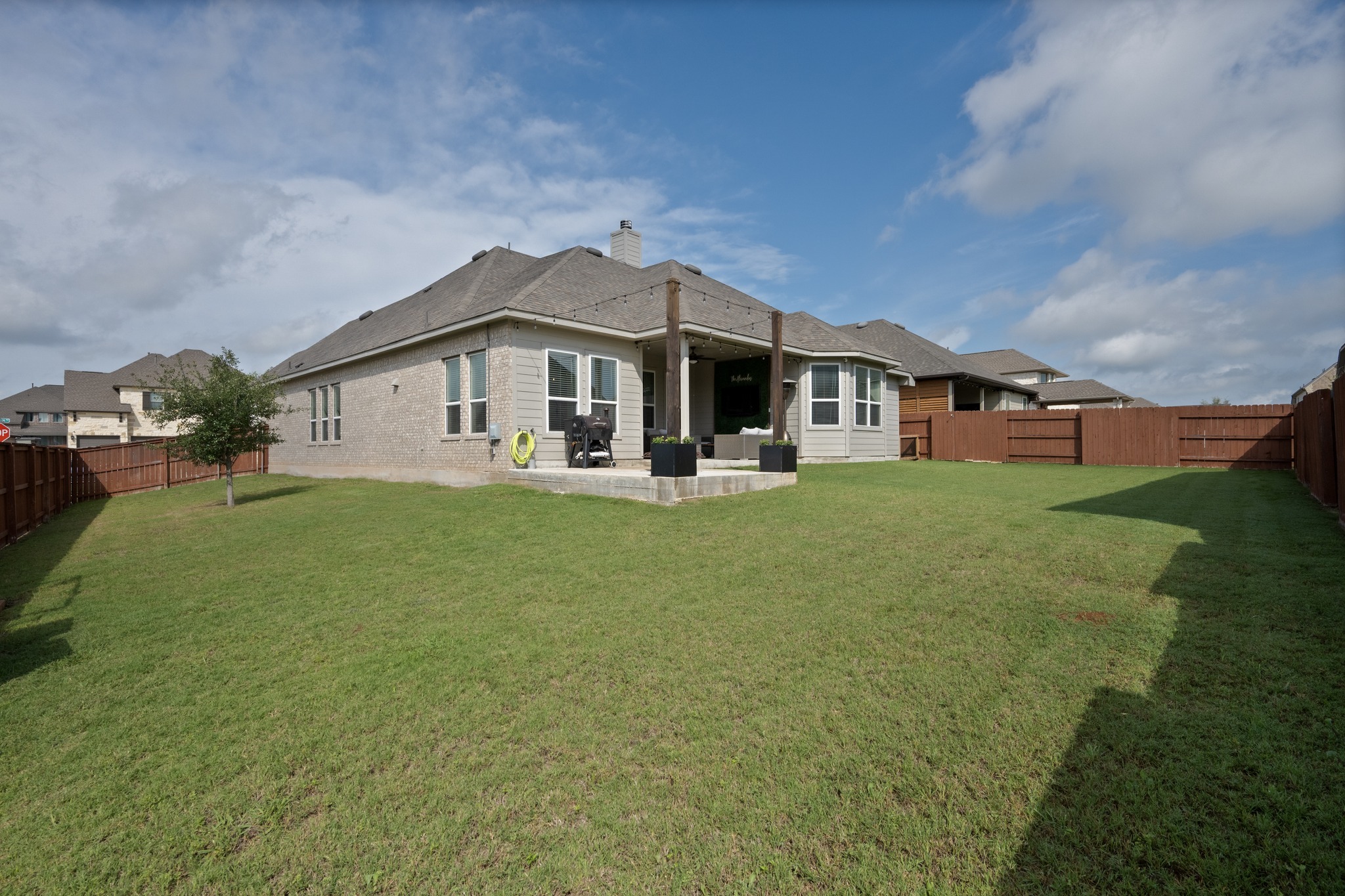 2100 Highland Ridge Road Georgetown, TX 78628 - Photo 30 of 30 A spacious backyard with mature green grass and a covered patio for outdoor enjoyment.