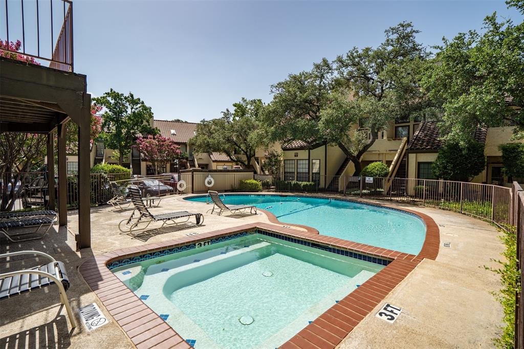 5590 Spring Valley Road, Unit H 203 Dallas, TX 75254 - Photo 2 of 27 Swimming pool area featuring a curved swimming pool, integrated spa, and concrete decking