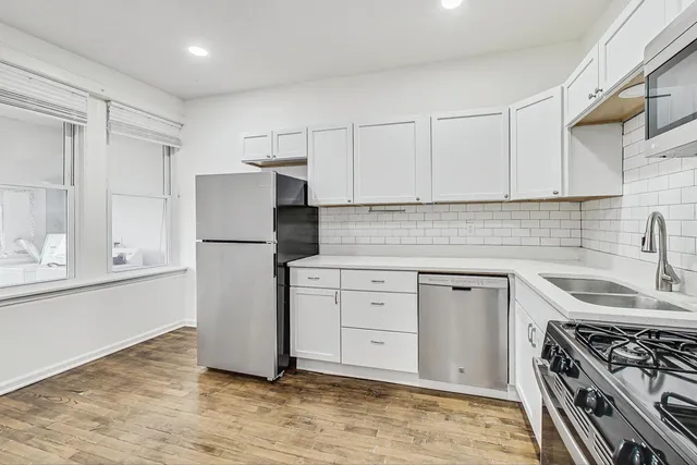 a kitchen with white cabinets and appliances
