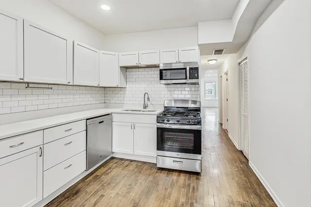 a kitchen with stainless steel appliances white cabinets and a sink