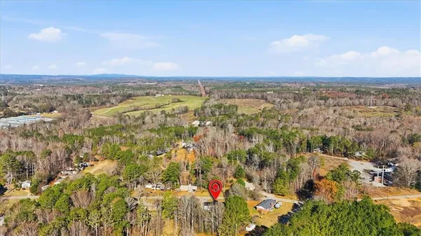 an aerial view of residential houses with outdoor space and trees