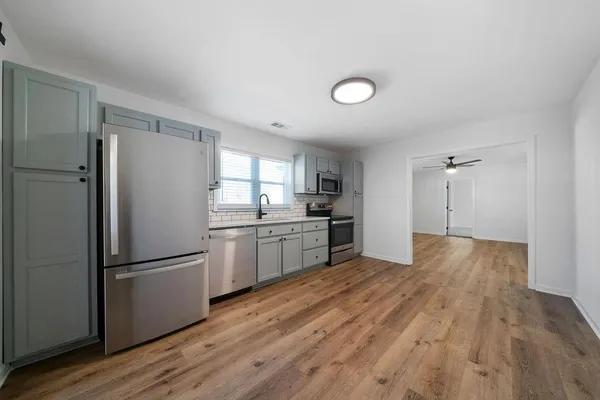 a kitchen with a refrigerator and a stove top oven