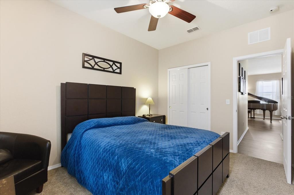 20900 Oldenburg Loop Mount Dora, FL 32757 - Photo 29 of 44 a bedroom with a large bed and a chandelier