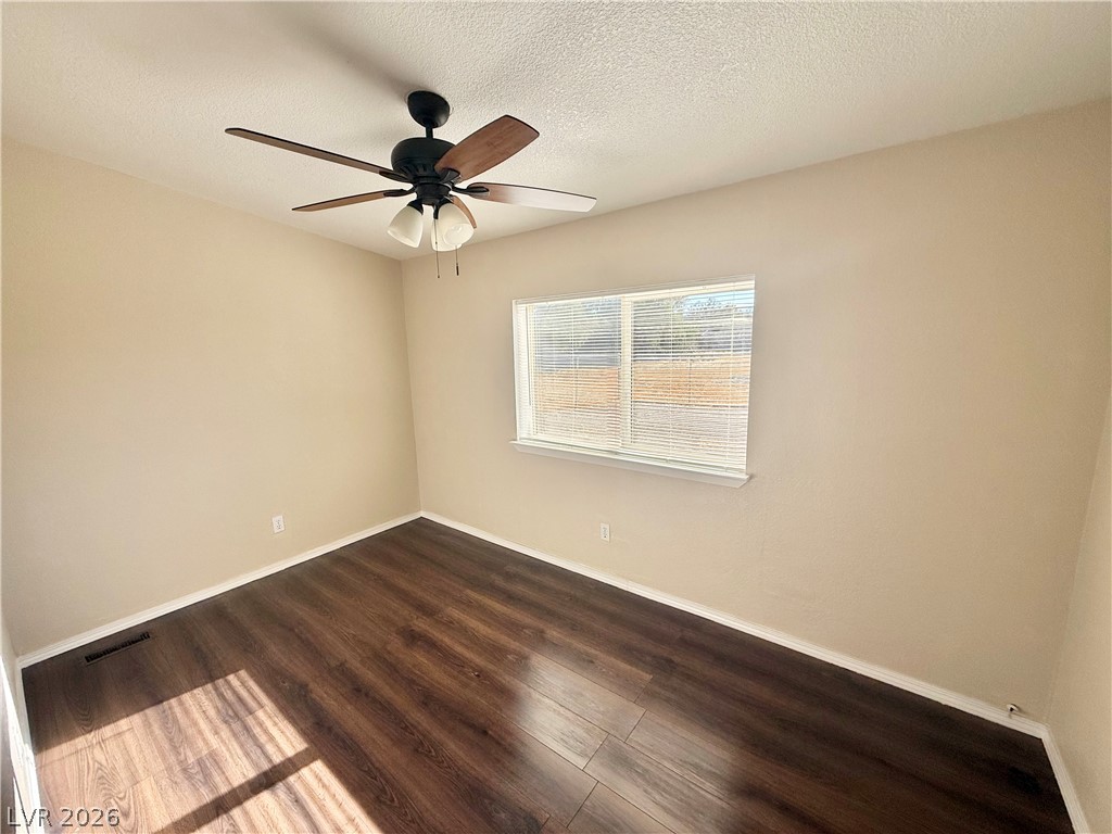 6450 Vicki Ann Road Pahrump, NV 89048 - Photo 8 of 9 Rich hardwood floors complement the neutral walls and a window offering natural light.