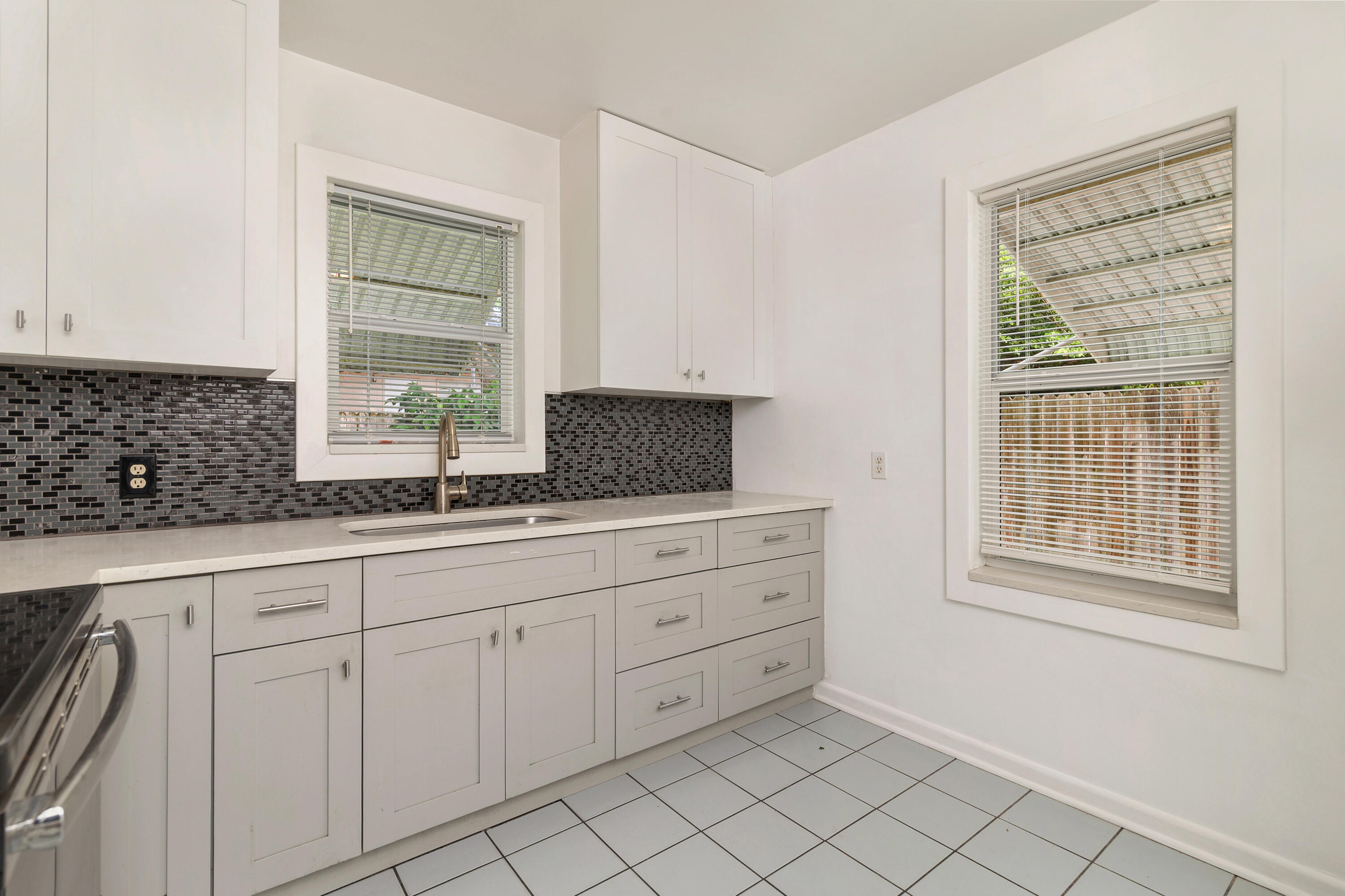 429 49th Street, Unit 2 West Palm Beach, FL 33407 - Photo 3 of 10 a kitchen with white cabinets and window