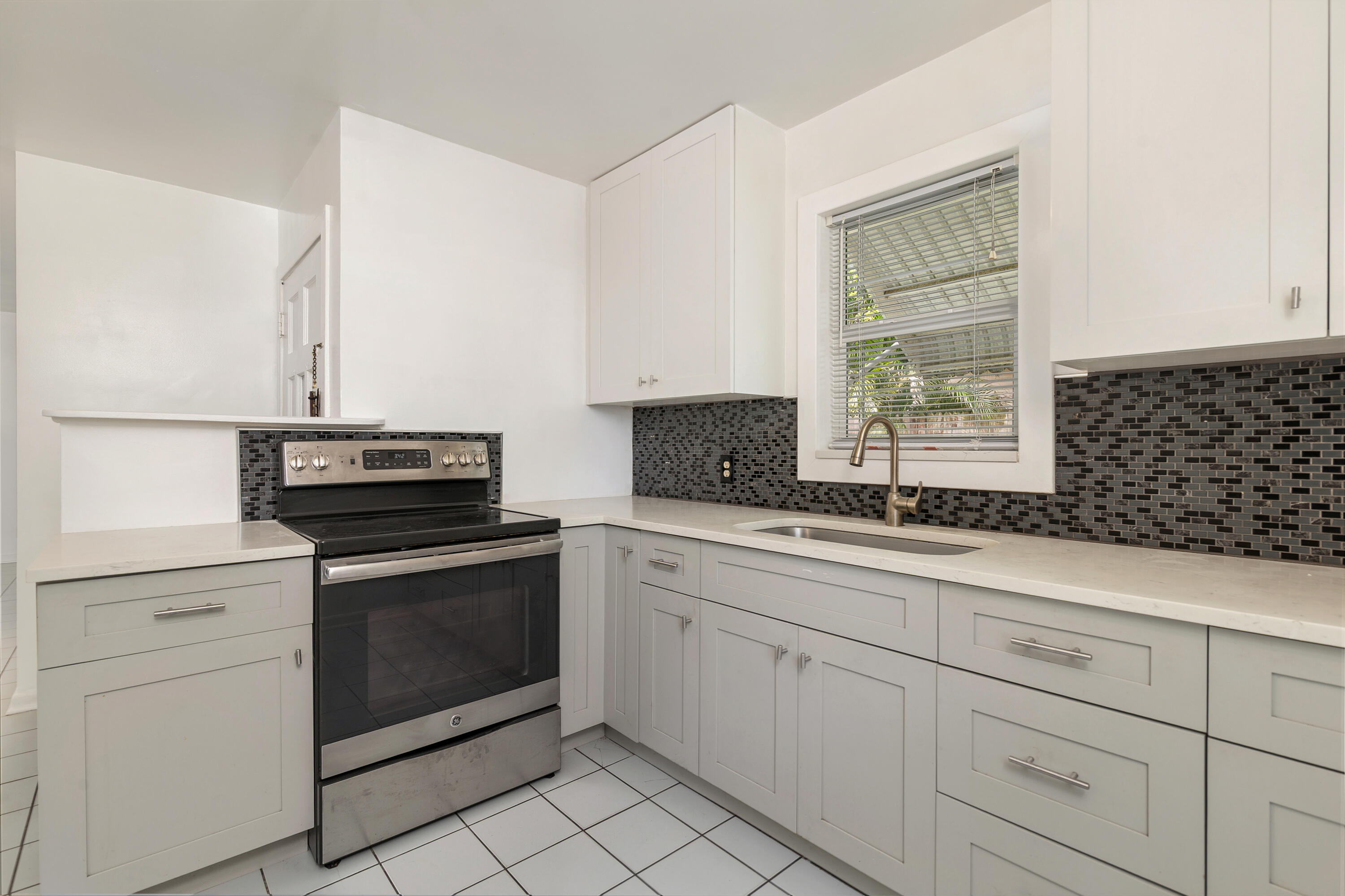 429 49th Street, Unit 2 West Palm Beach, FL 33407 - Photo 4 of 10 a kitchen with white cabinets and appliances