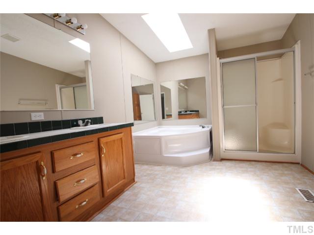5949 Oxford Road Timberlake, NC 27583 - Photo 8 of 12 a spacious bathroom with a granite countertop sink mirror and bathtub