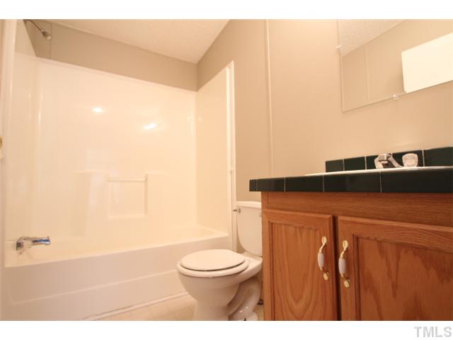 5949 Oxford Road Timberlake, NC 27583 - Photo 10 of 12 a bathroom with a toilet a sink and a bathtub