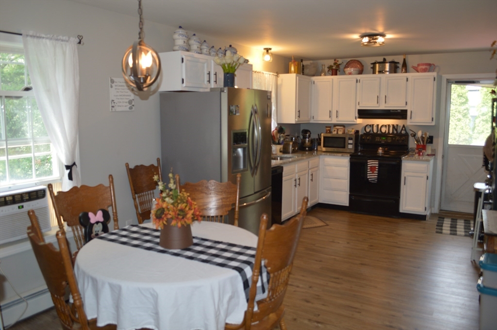 75 Eagle View Drive Douglas, MA 01516 - Photo 7 of 28 a kitchen with stainless steel appliances granite countertop a refrigerator dining table chairs and a chandelier
