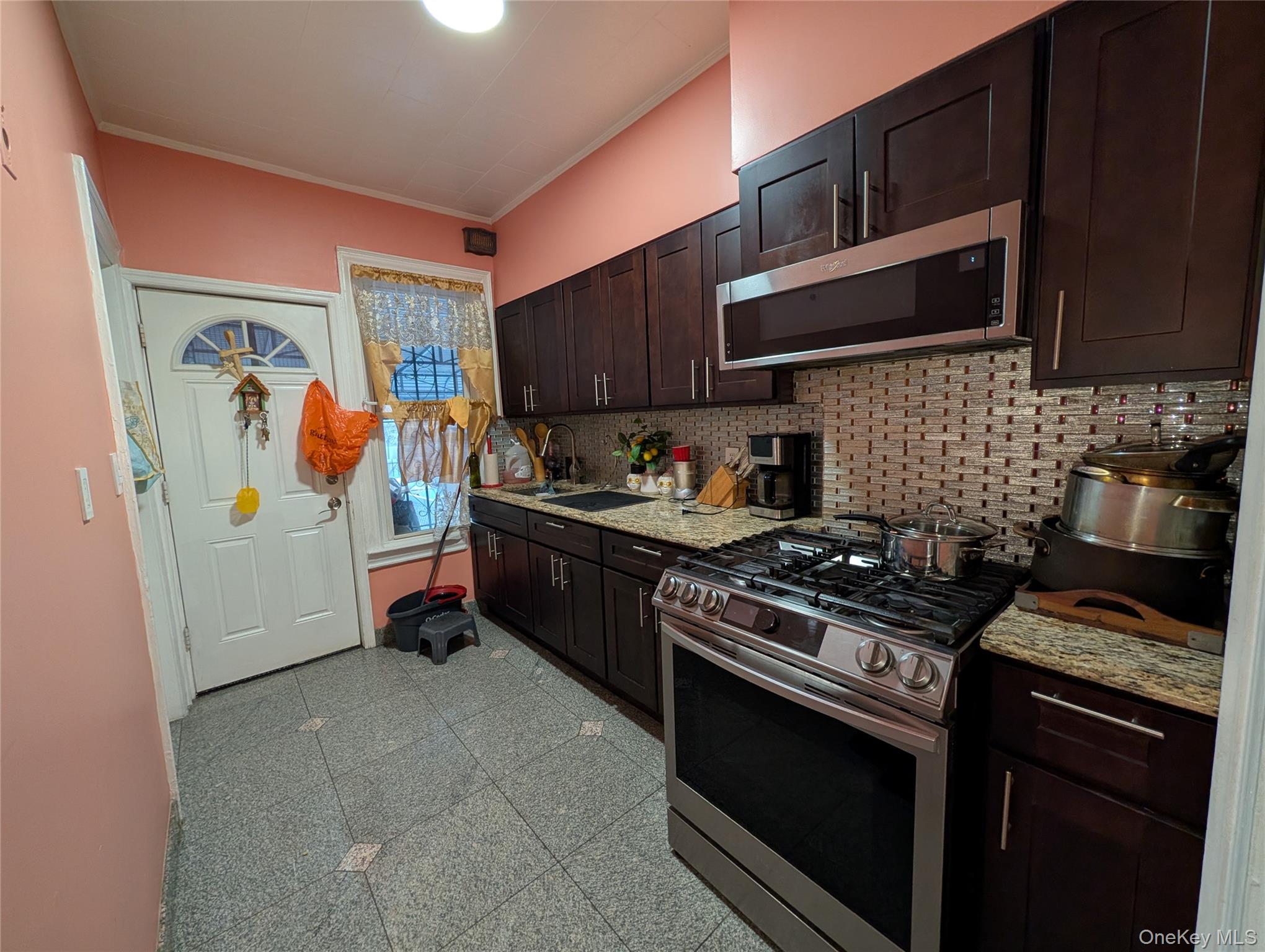 90-46 76th Street Queens, NY 11421 - Photo 12 of 32 a kitchen with stainless steel appliances granite countertop a stove and a microwave
