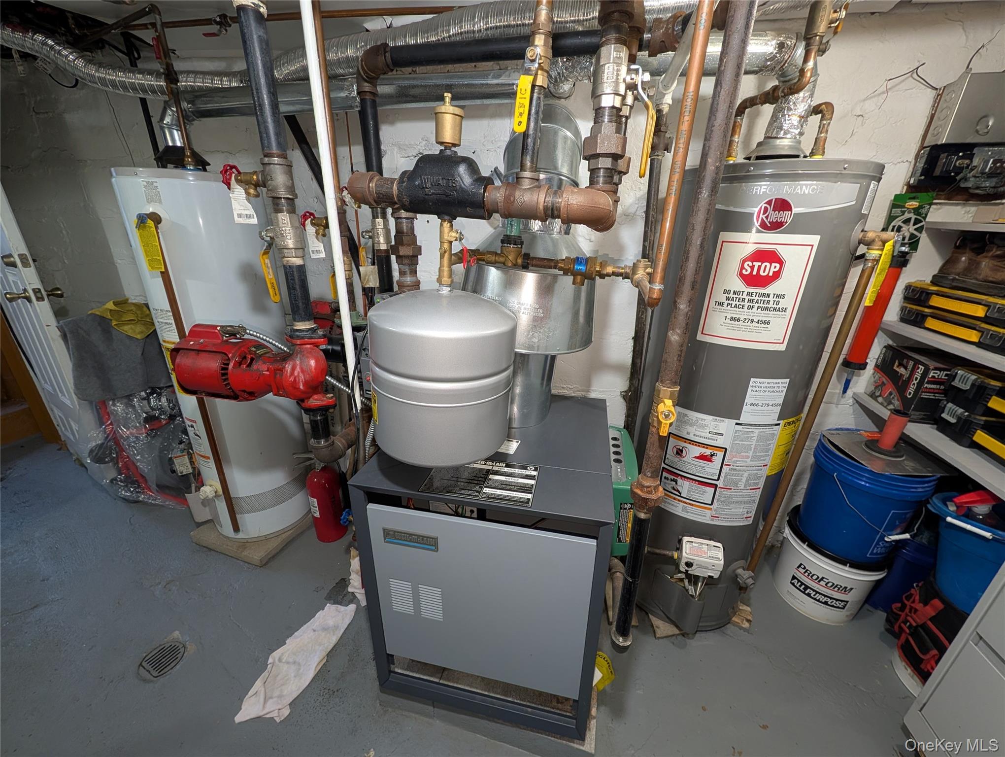 90-46 76th Street Queens, NY 11421 - Photo 30 of 32 a view of a storage room with water heater and racks