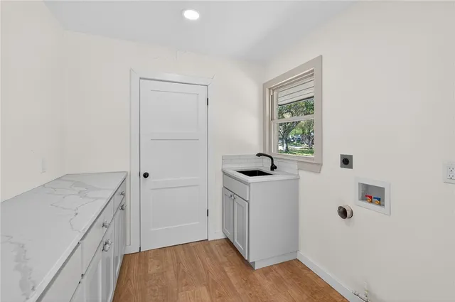 a kitchen with stainless steel appliances white cabinets and wooden floor