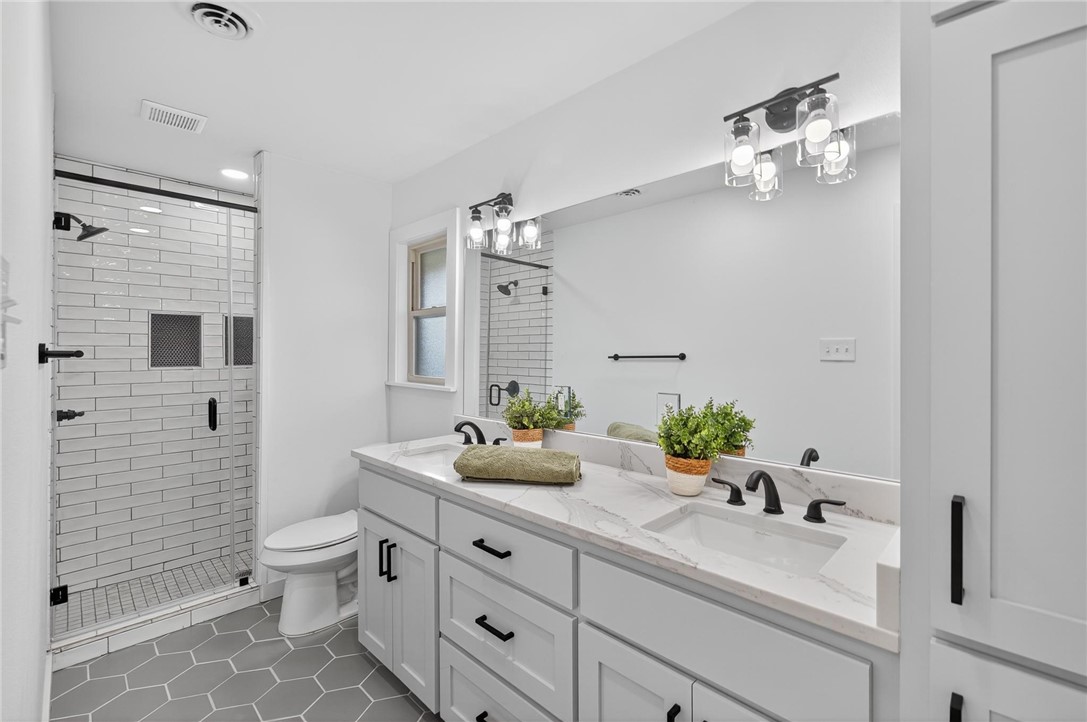 126 Rainbow Lane Corpus Christi, TX 78411 - Photo 30 of 40 a bathroom with a sink a toilet and a large mirror