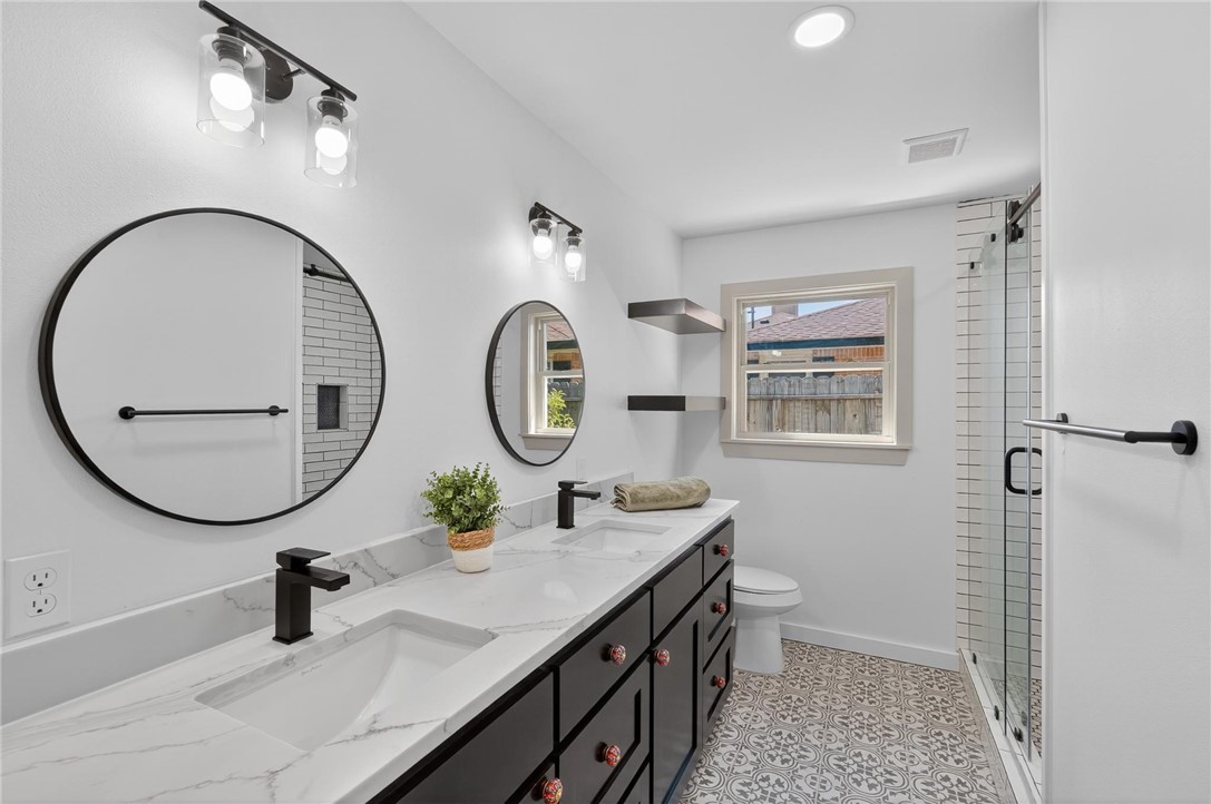 126 Rainbow Lane Corpus Christi, TX 78411 - Photo 33 of 40 a bathroom with a toilet a sink and a mirror
