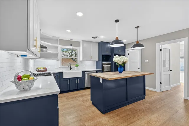 a kitchen with stainless steel appliances kitchen island granite countertop a stove a sink and a microwave