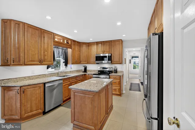 a kitchen with granite countertop a sink stainless steel appliances and cabinets