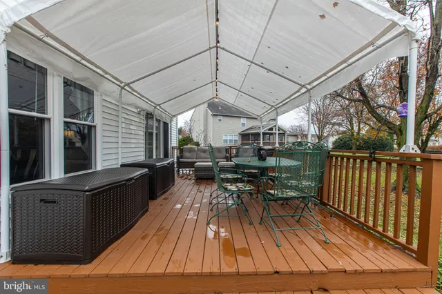 a backyard of a house with wooden table and chairs