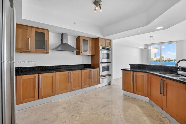 a large kitchen with stainless steel appliances granite countertop a sink and cabinets