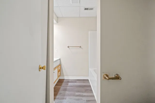 a view of a hallway with wooden floor and closet