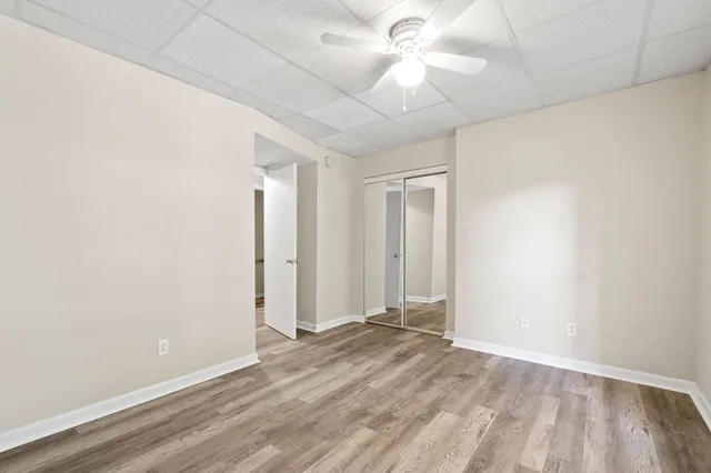 an empty room with a ceiling fan and a window