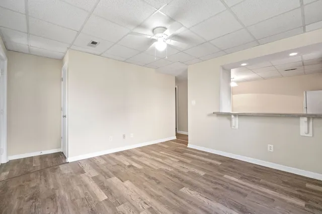 an empty room with a ceiling fan and wooden floor